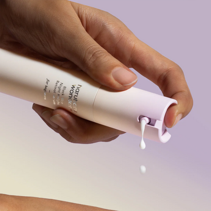 Sérum blanc distribué depuis le flacon-pompe tenu entre les mains
