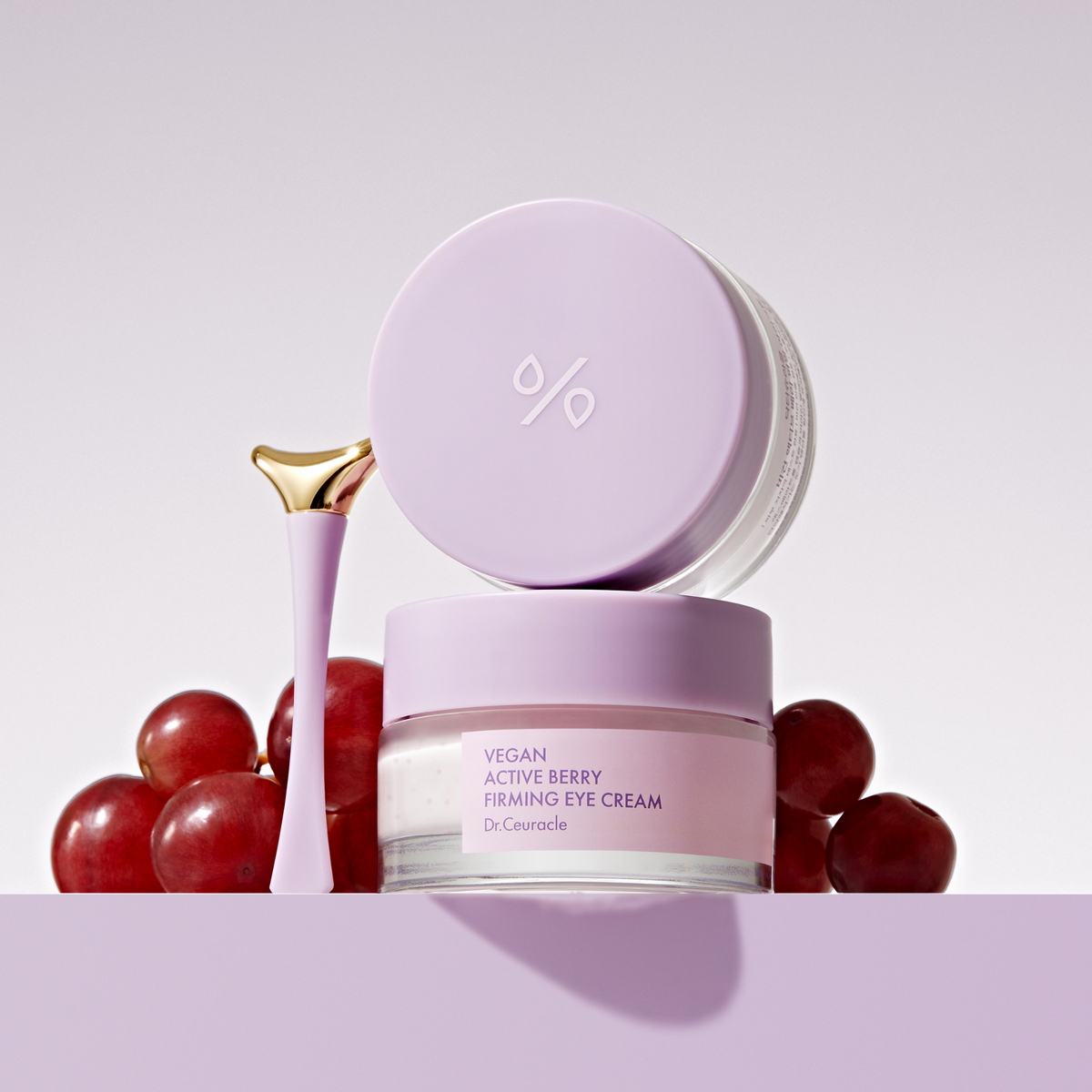 Pots mauves de contour des yeux avec applicateur et raisins