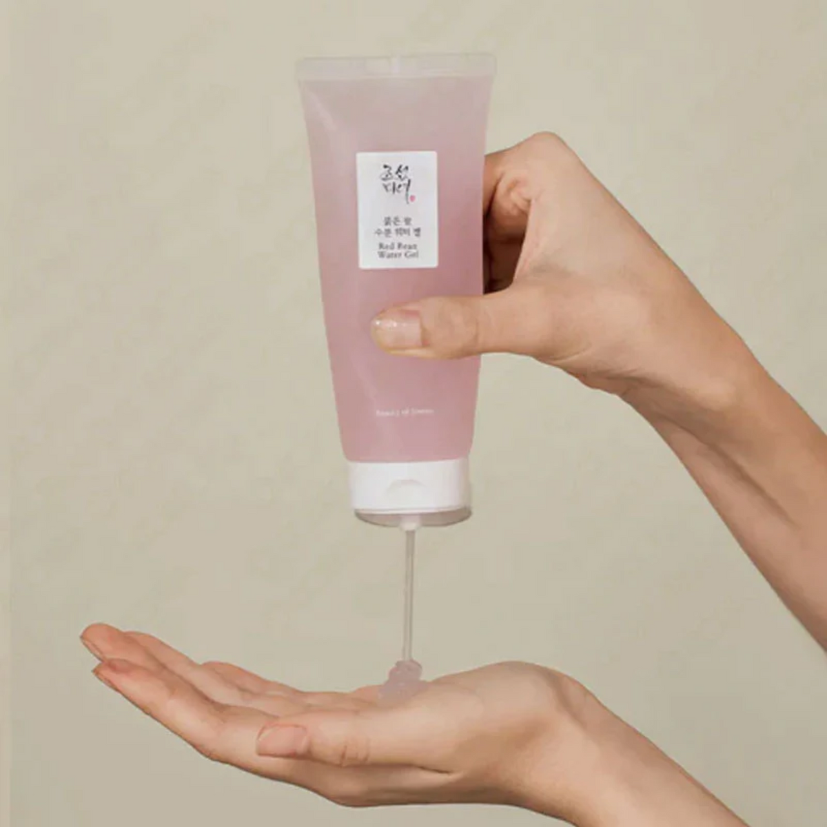 Gel translucide rosé distribué dans la paume depuis un tube