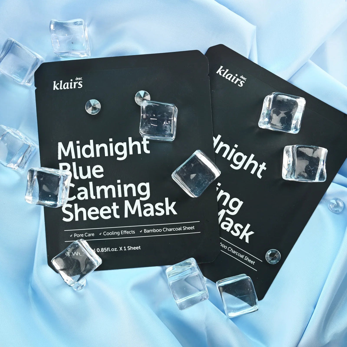 Sachets noirs de masques avec des glaçons sur un tissu bleu