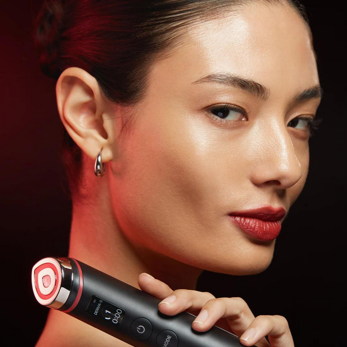 Appareil noir à tête lumineuse rouge présenté près du visage