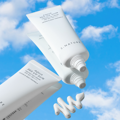Tubes blancs de solaire ouverts devant un ciel bleu avec un ruban de crème