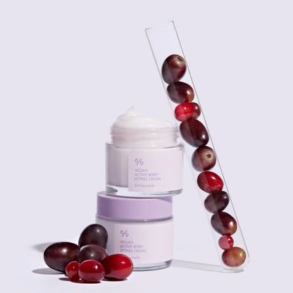 Pots mauves de crème près de raisins et de baies