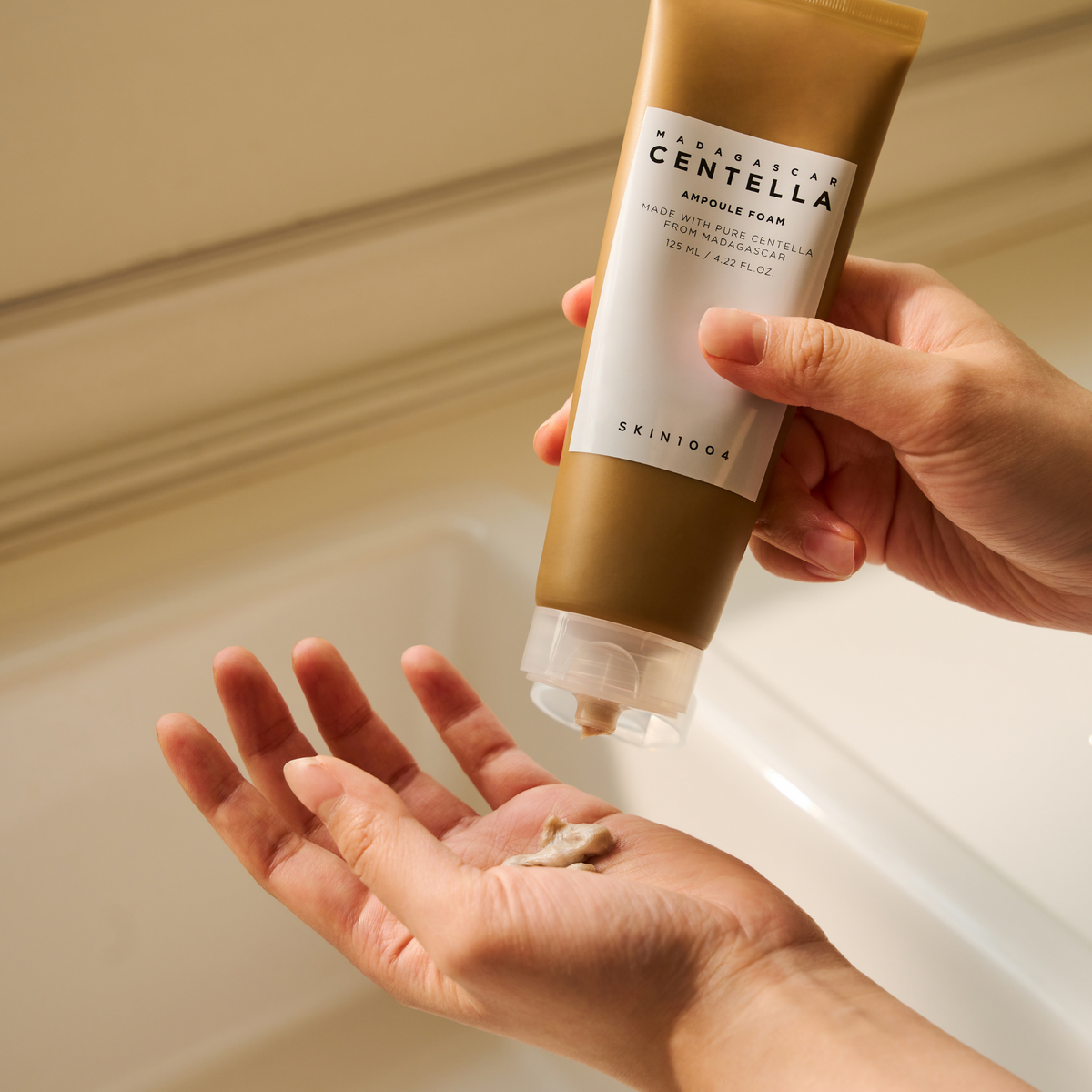 Nettoyant beige distribué depuis le tube dans la paume