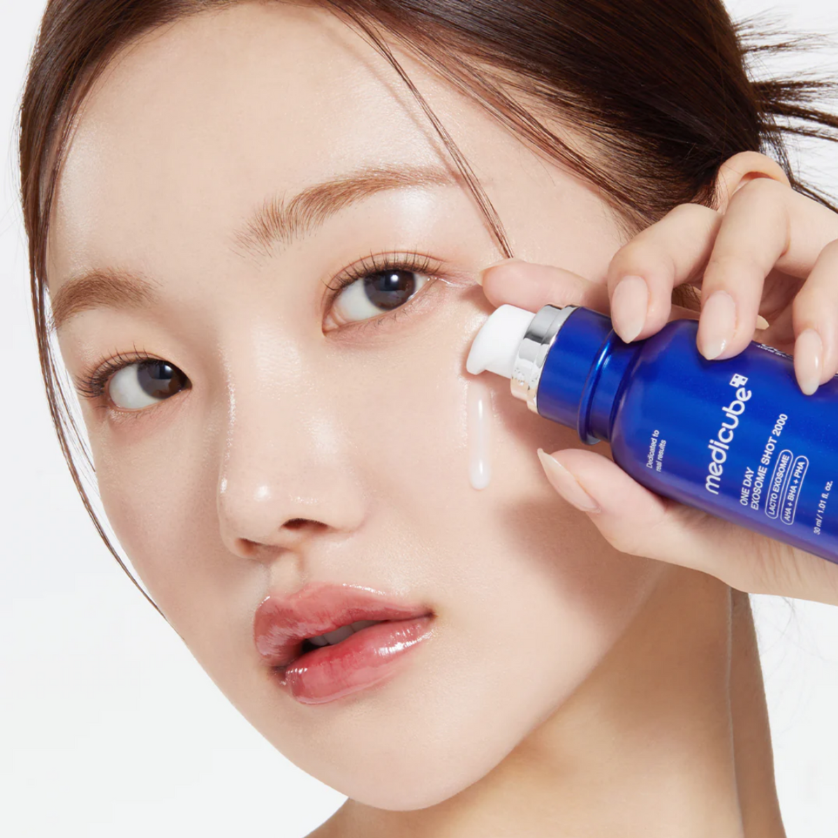 Ampoule distribuée depuis le flacon bleu sur la joue