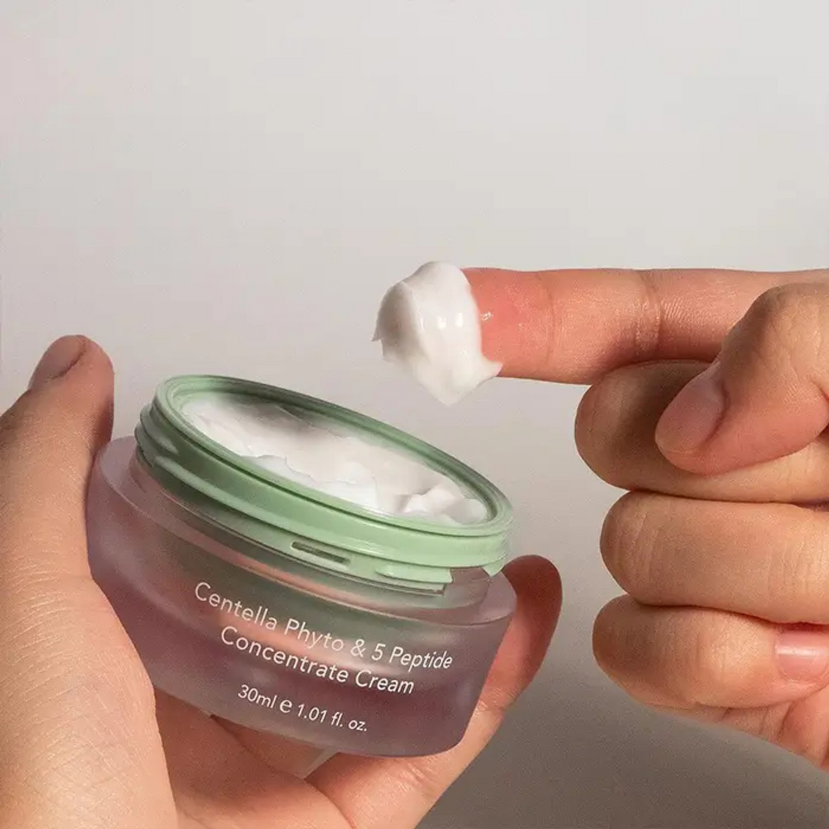 Crème blanche prélevée du bout du doigt dans le pot ouvert