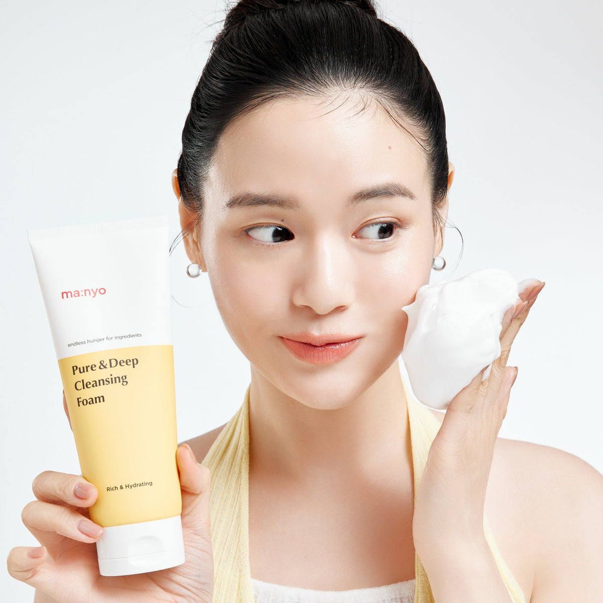 Nettoyant présenté avec une boule de mousse dans la main près du visage