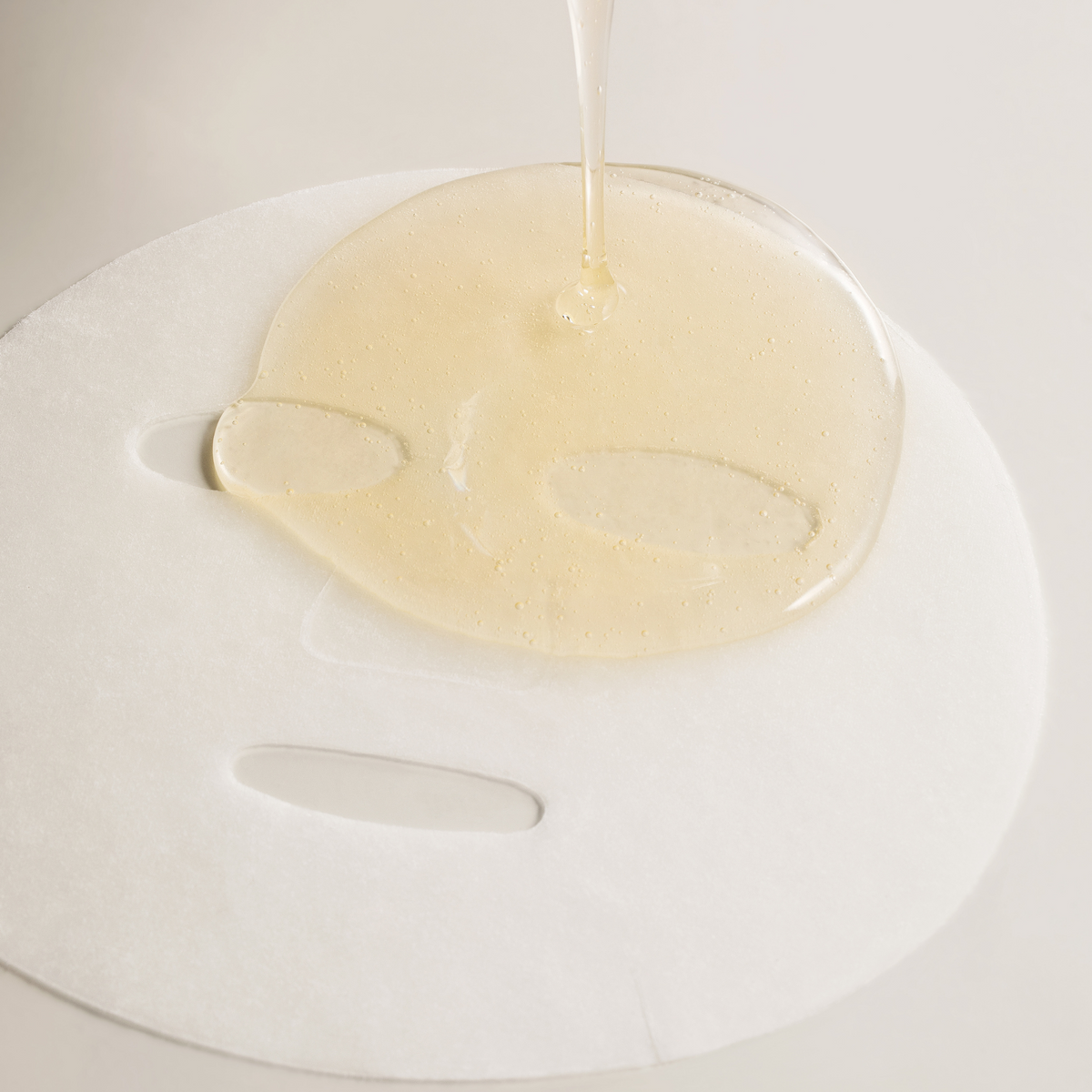 Essence dorée versée sur le masque blanc déplié