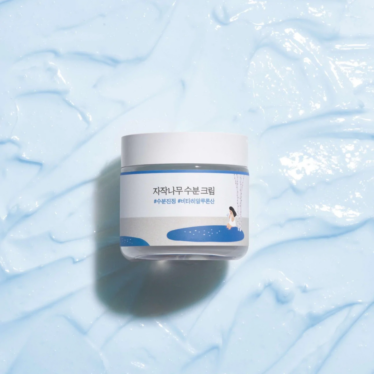 Pot de crème posé sur une texture de gel bleu clair