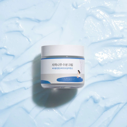 Pot de crème posé sur une texture de gel bleu clair