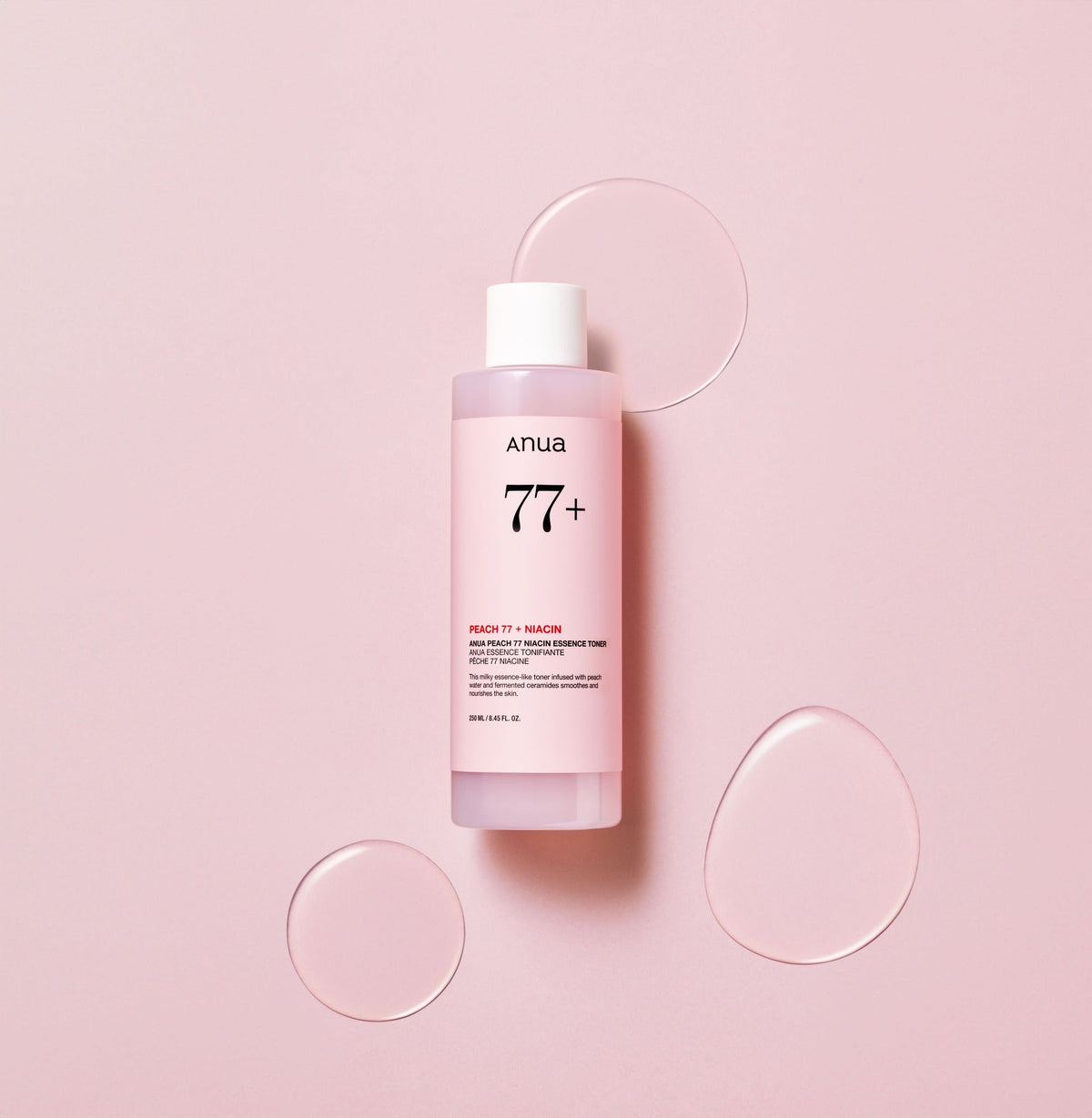 Flacon rose de lotion entouré de flaques transparentes