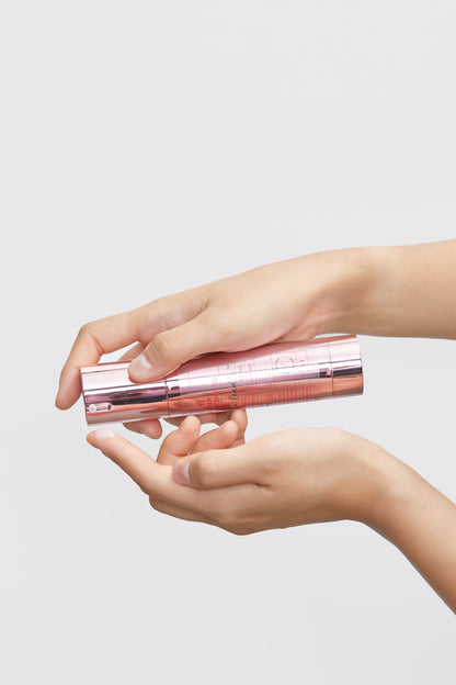 Soin distribué sur le bout du doigt avec le flacon-pompe rose