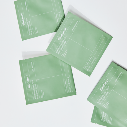 Plusieurs sachets verts de masque disposés en diagonale