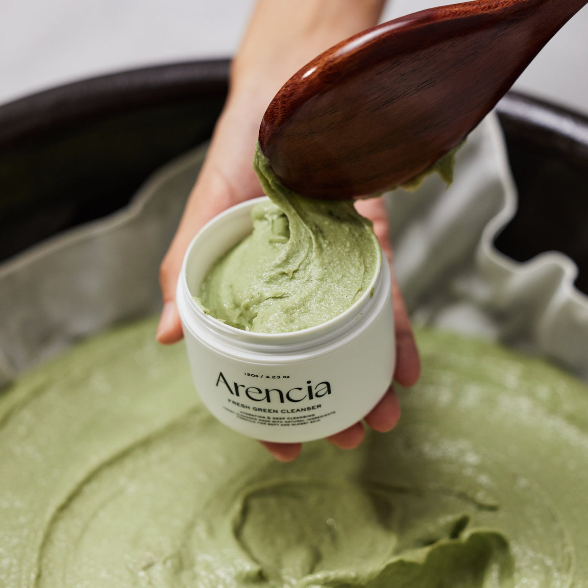 Pâte nettoyante verte versée dans un pot avec une spatule en bois