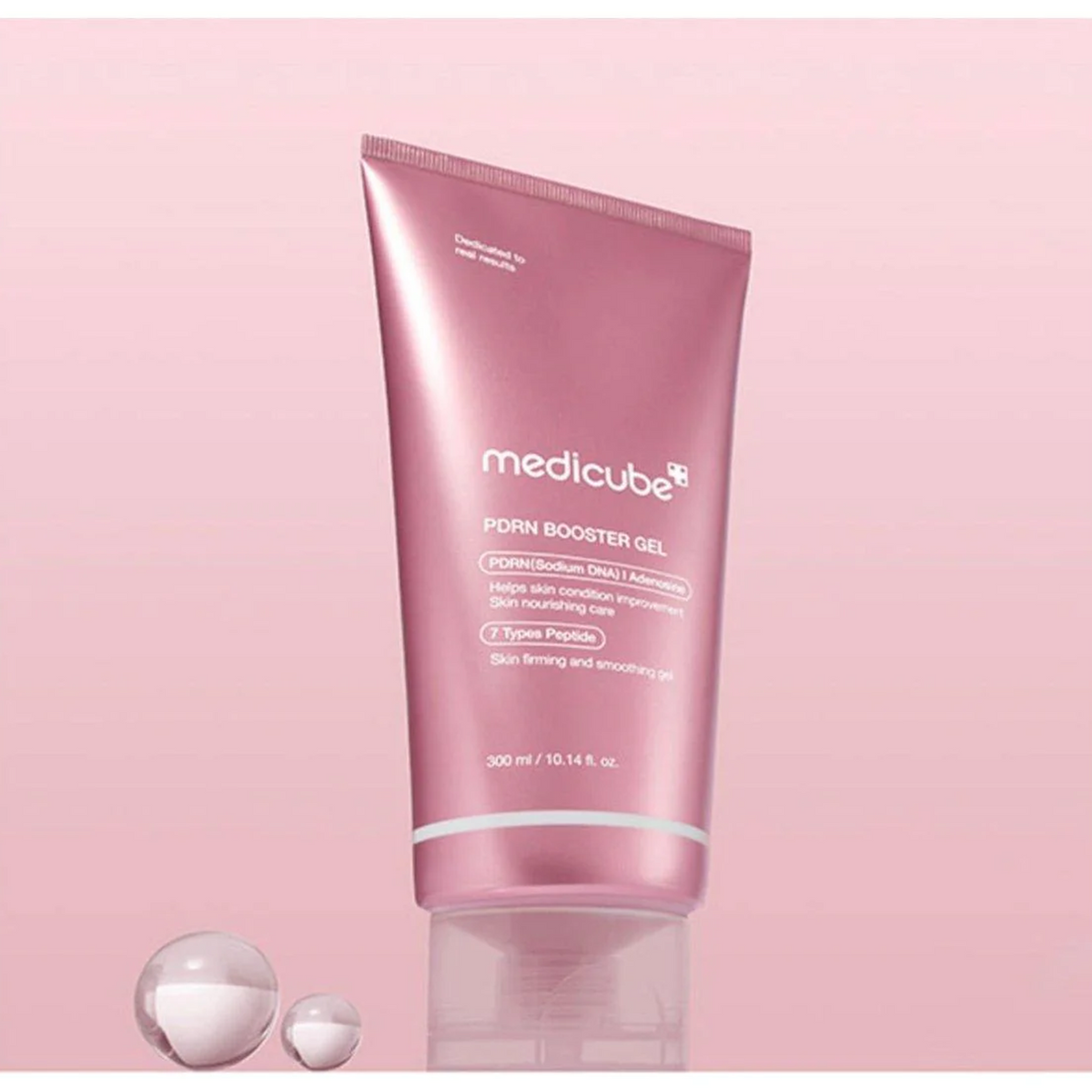 Tube rose de gel près de sphères transparentes