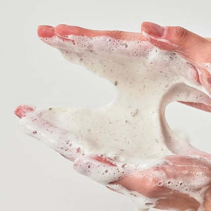 Mousse nettoyante à fines particules étirée entre les mains