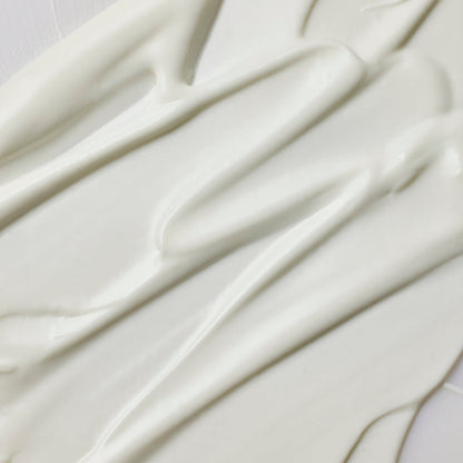 Texture blanche de sérum solaire étalée en bandes