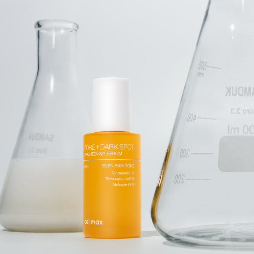 Flacon de sérum orange près de récipients de laboratoire