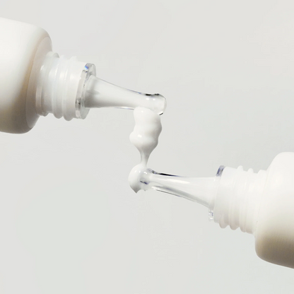 Gel-crème blanc entre les embouts de deux tubes
