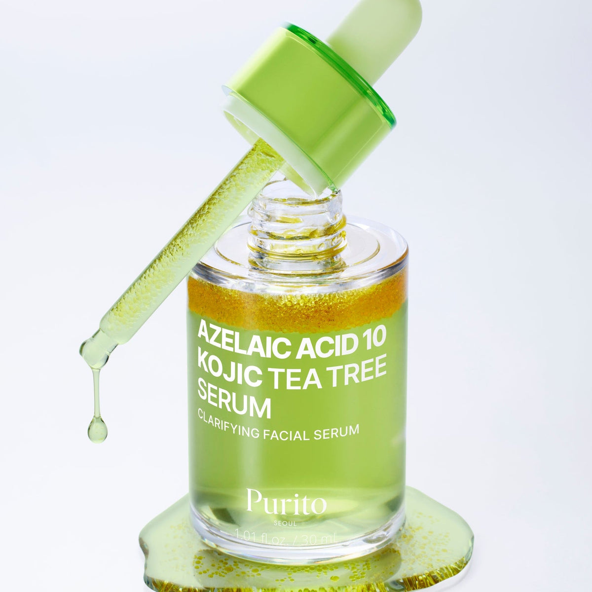Flacon de sérum vert ouvert avec sa pipette et des particules jaunes