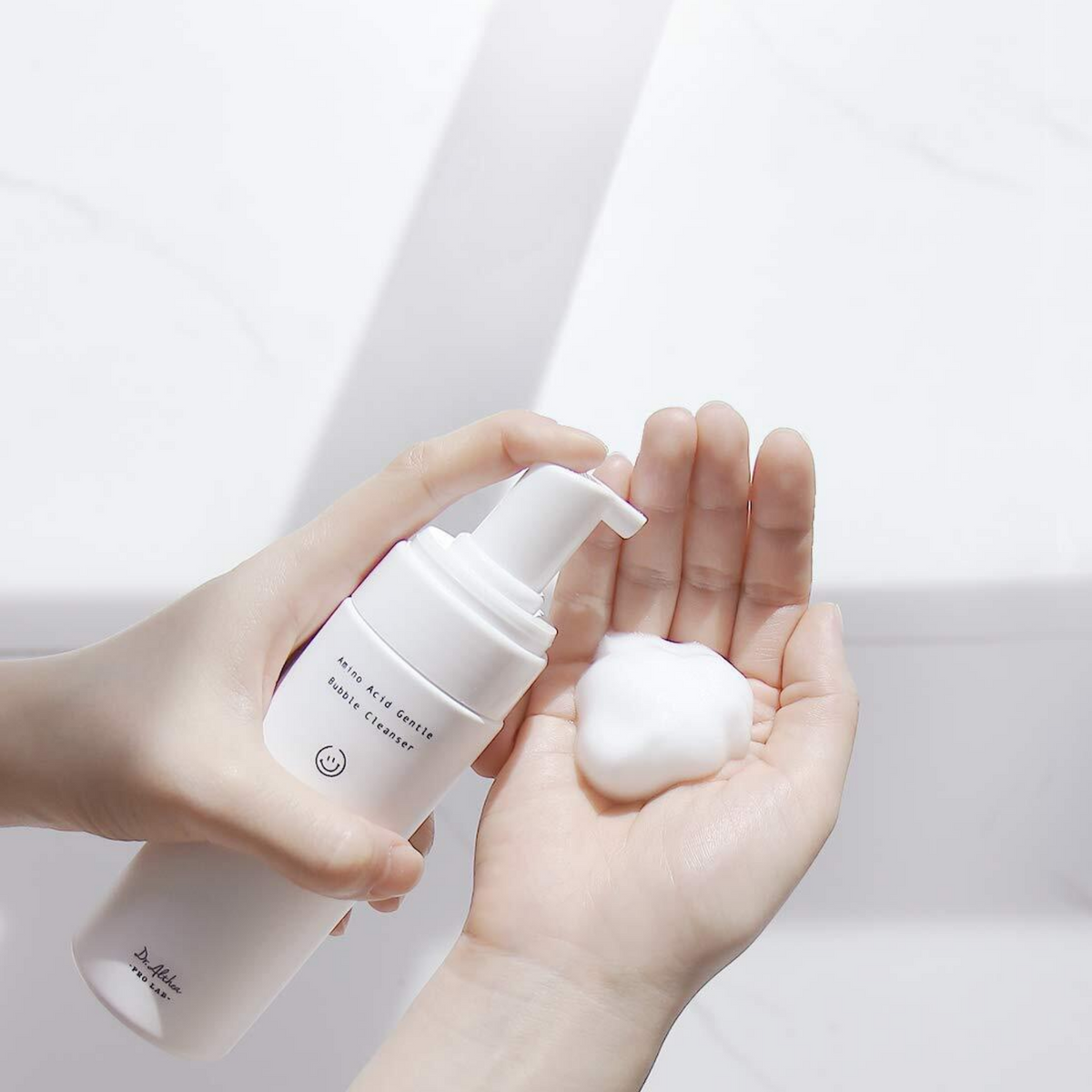 Mousse blanche distribuée dans la paume avec le flacon-pompe