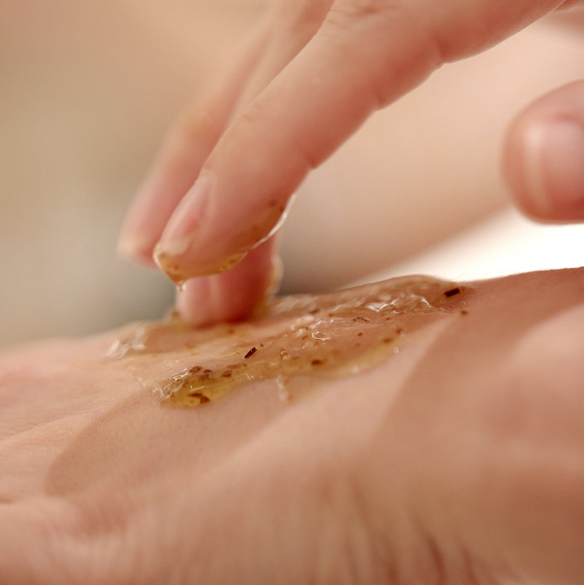 Masque-gel ambré étalé avec les doigts sur le dos de la main