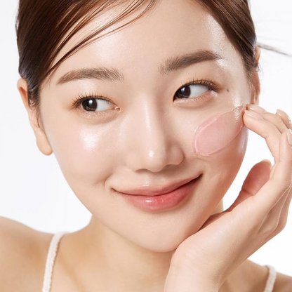 Gel rose étalé sur la joue du bout des doigts