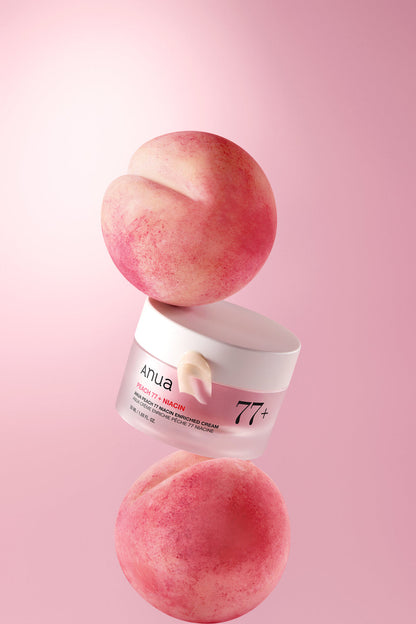 Pot de crème rose disposé entre deux pêches