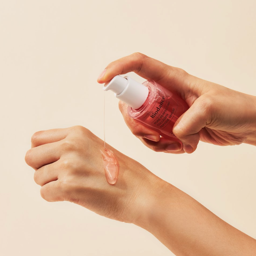 Sérum rose déposé sur le dos de la main avec la pompe