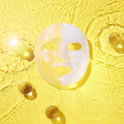 Masque hydrogel déplié sur un fond jaune entouré de sphères