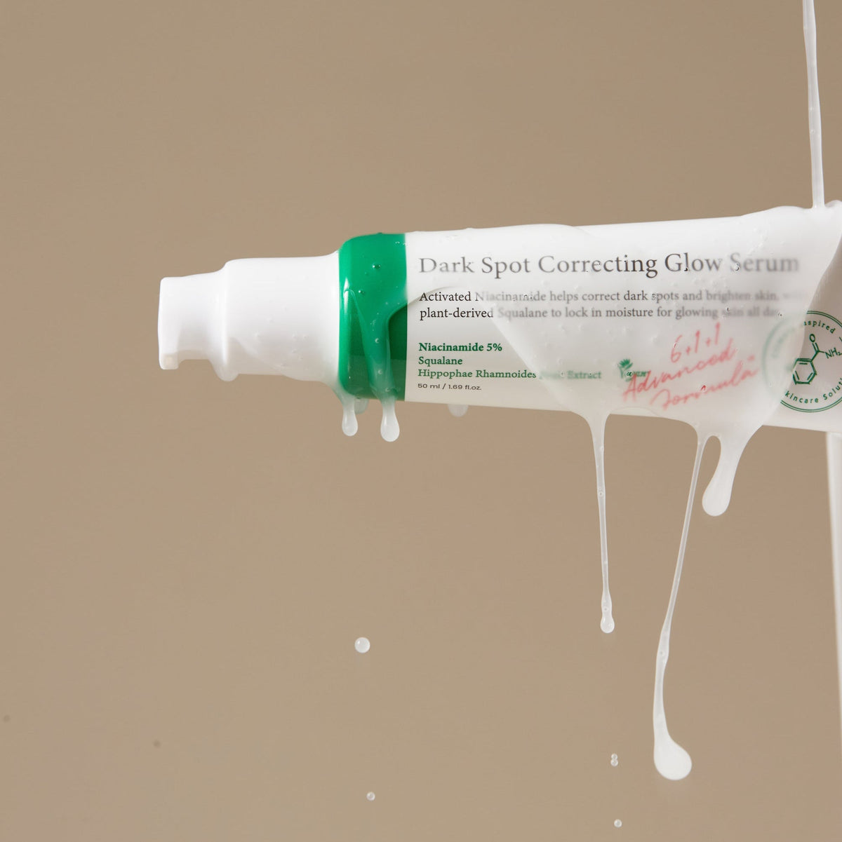 Sérum blanc coulant sur un tube, avec les mentions niacinamide et squalane