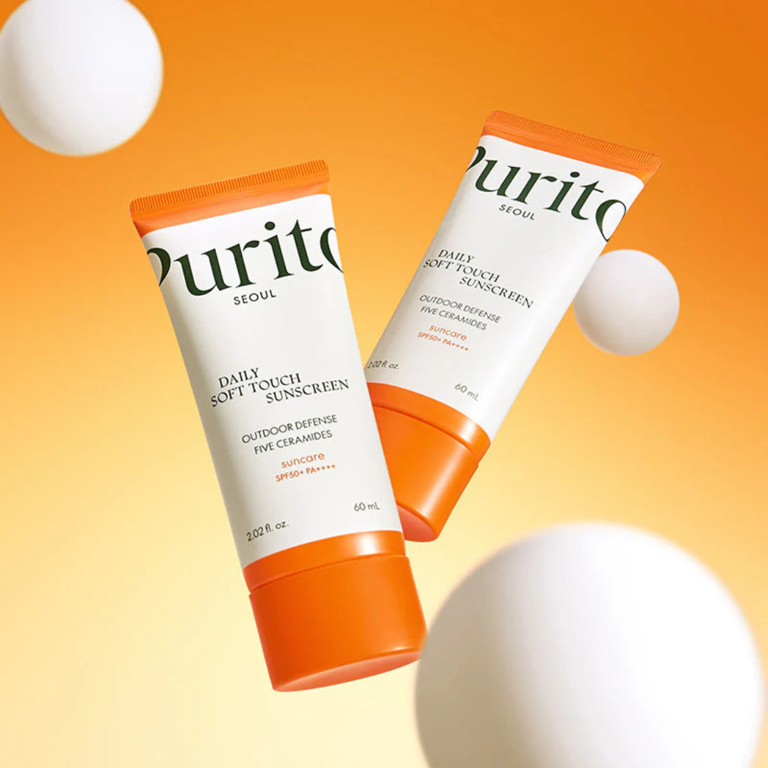 Deux tubes de solaire à bouchon orange dans un décor de sphères blanches