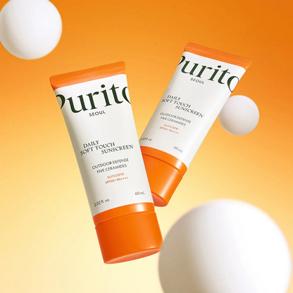 Deux tubes de solaire à bouchon orange dans un décor de sphères blanches