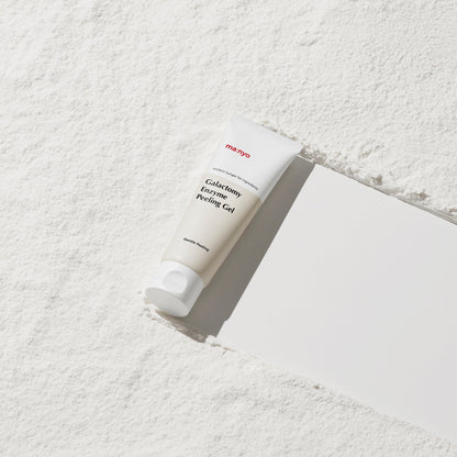 Tube blanc de gel exfoliant sur une surface poudrée
