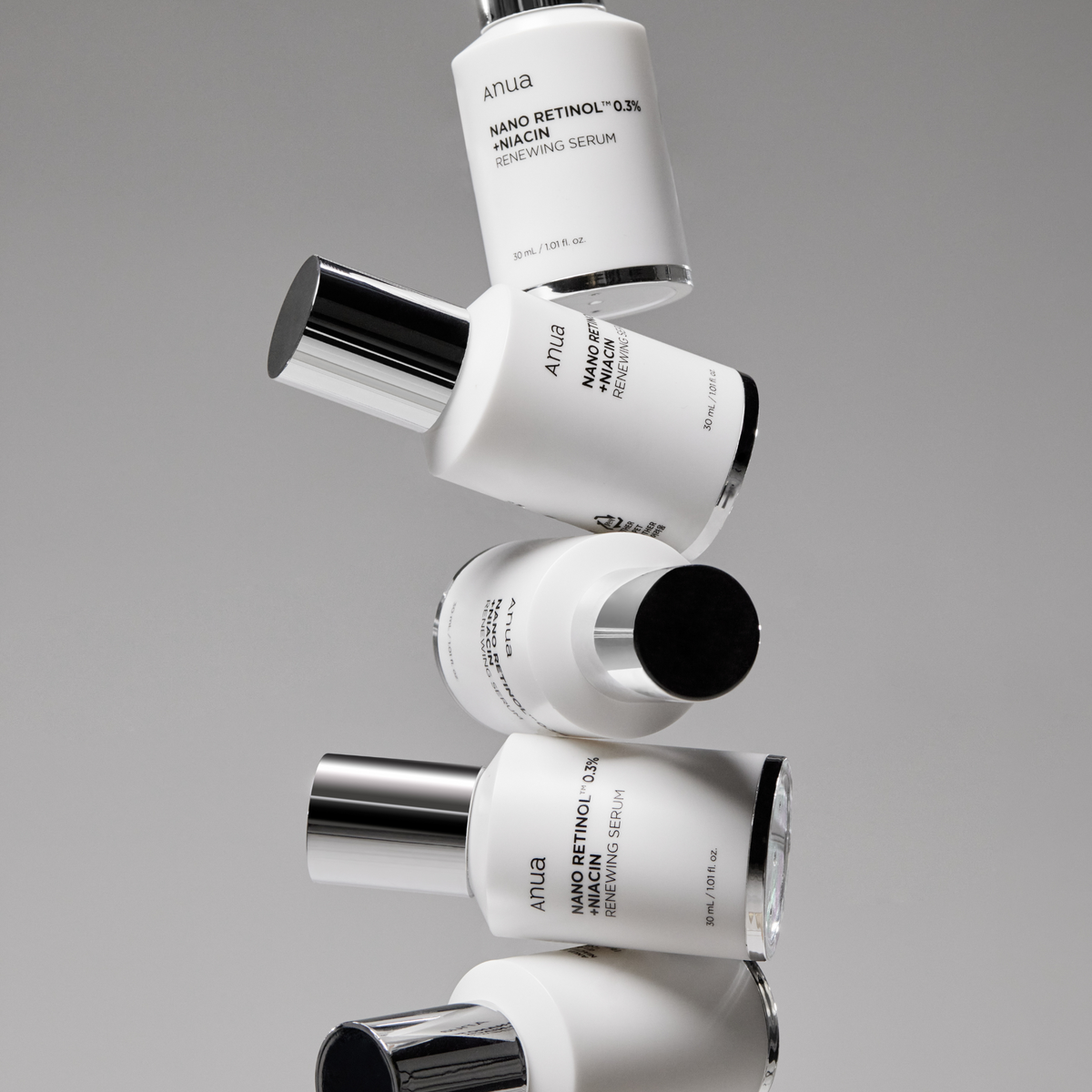 Plusieurs flacons blancs de sérum disposés en diagonale