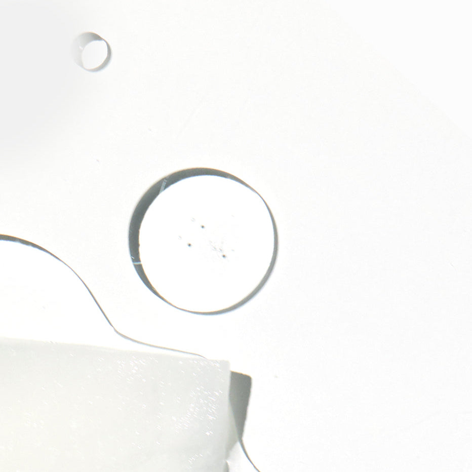 Feuille de masque blanche imbibée près de gouttes transparentes