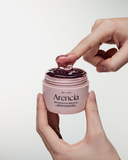 Texture gélifiée rouge étirée entre le doigt et le pot