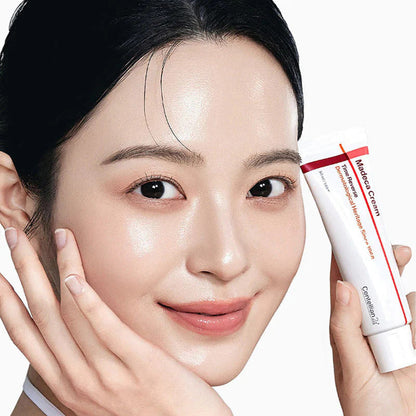 Tube blanc et rouge de crème tenu près du visage