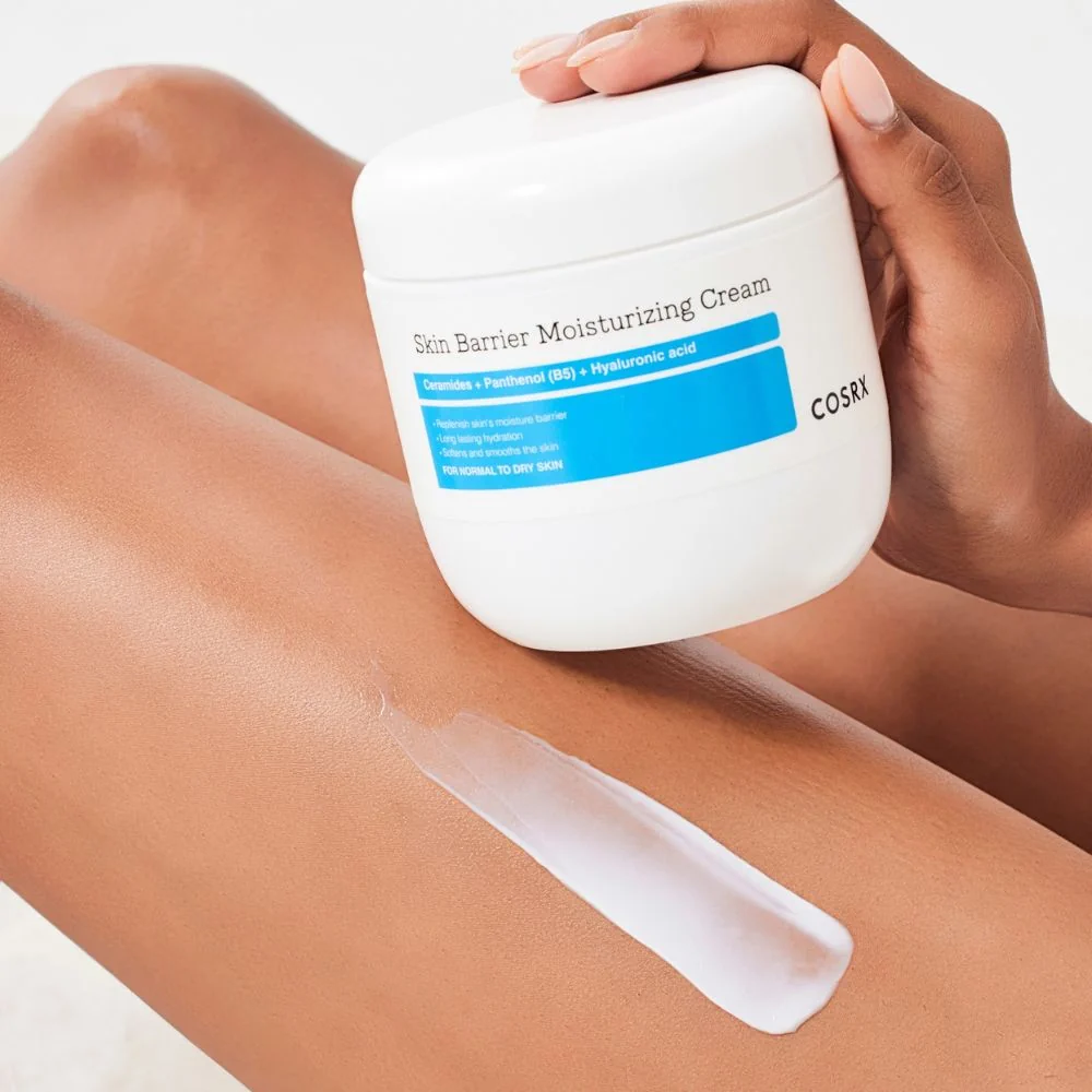 Trace de crème blanche étalée sur la jambe près du pot