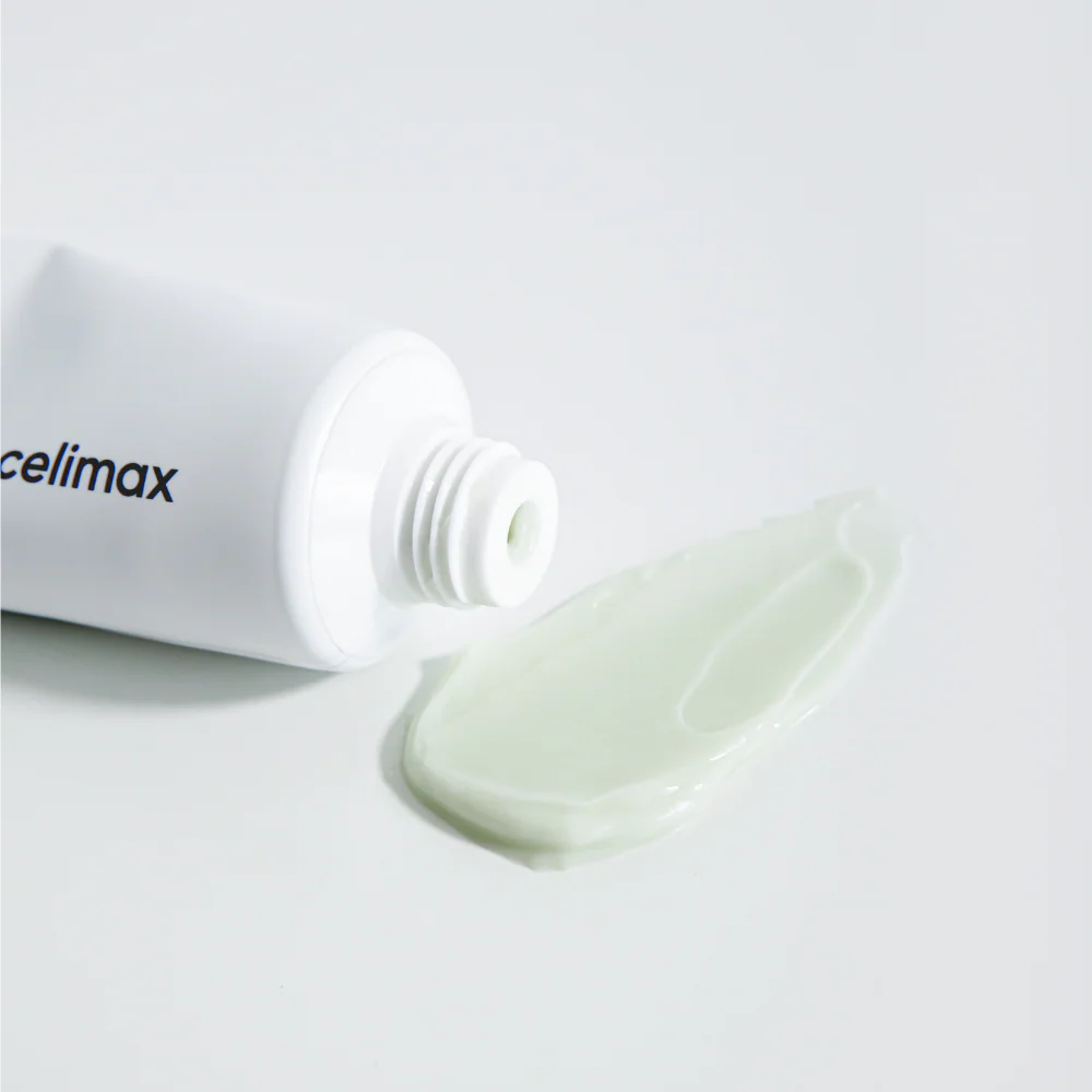 Crème vert pâle déposée près du tube ouvert