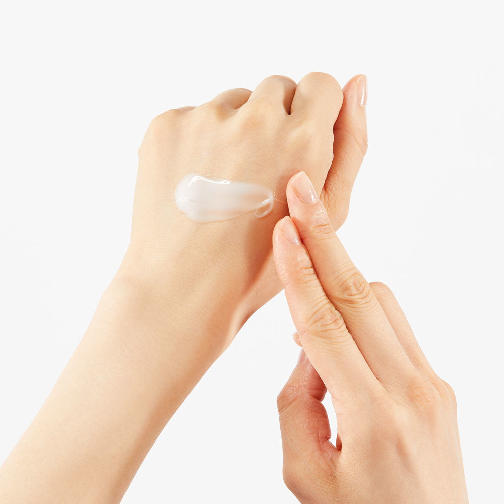 Crème blanche étalée avec les doigts sur le dos de la main
