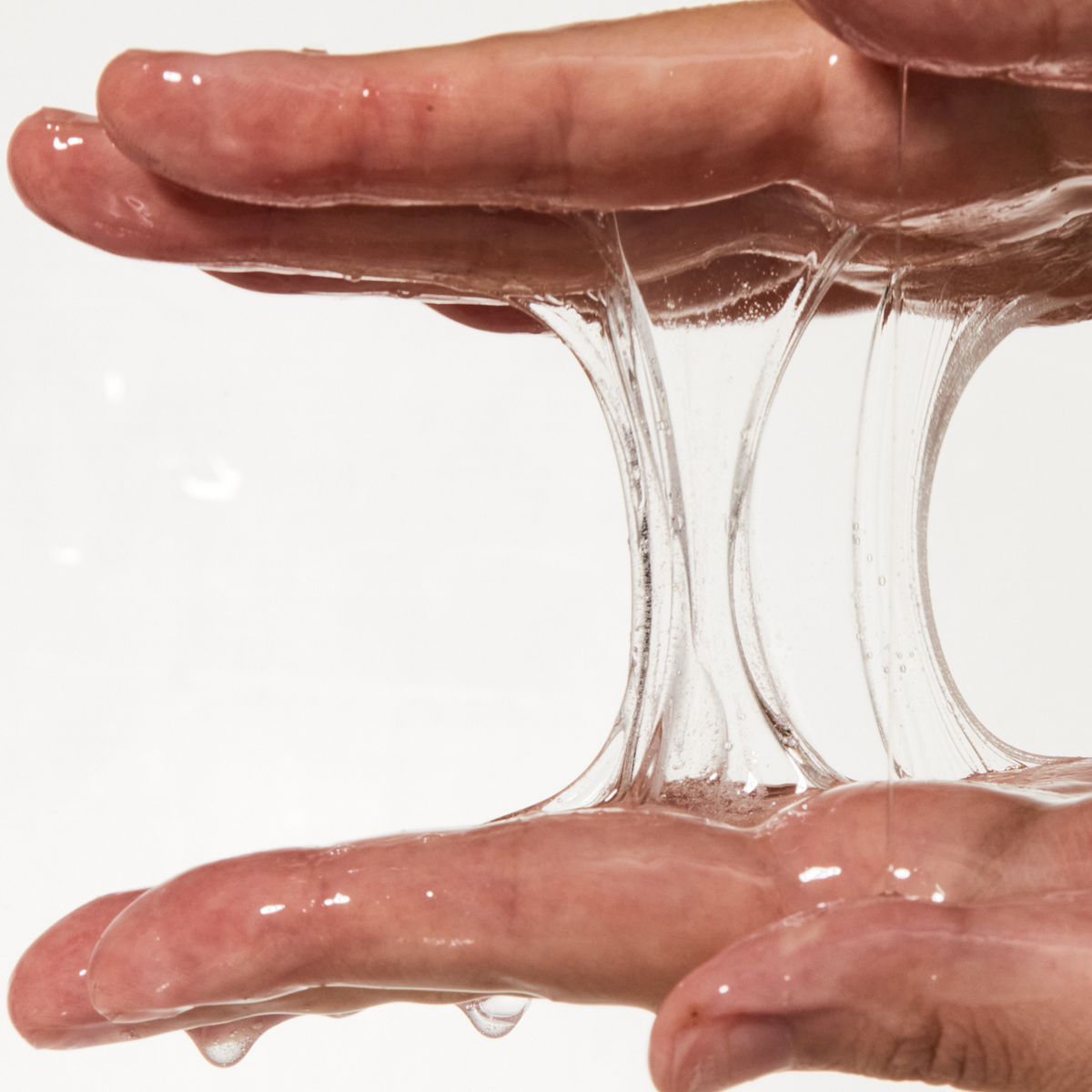 Texture du sérum transparent étirée entre les doigts