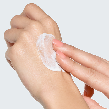 Crème solaire blanche étalée avec les doigts sur le dos de la main