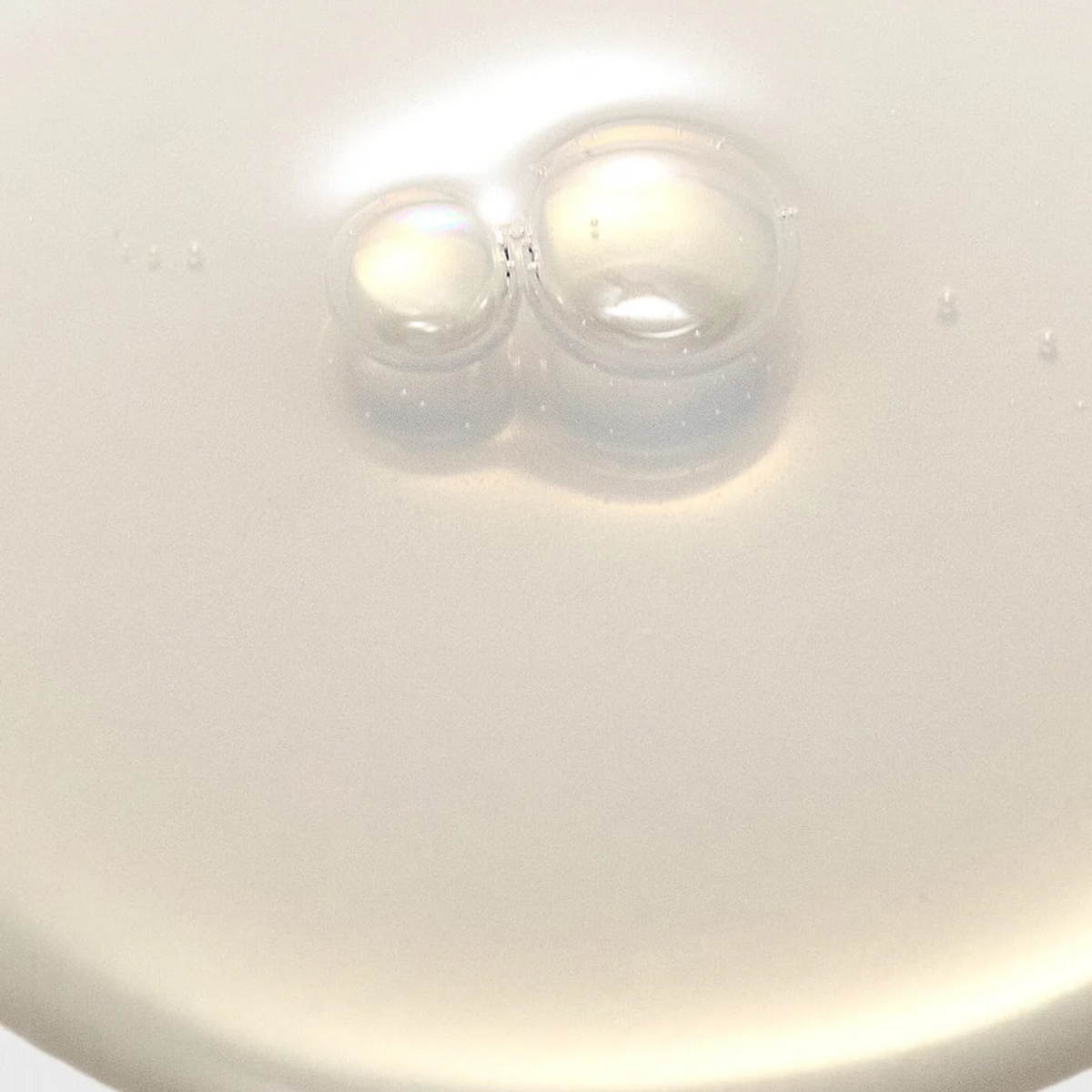 Gros plan sur la texture laiteuse de la lotion et ses bulles
