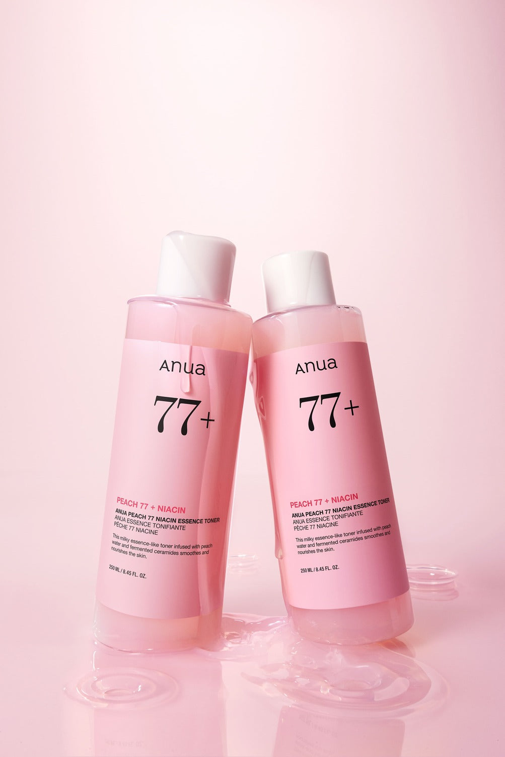 Deux flacons roses de lotion dans une flaque de liquide