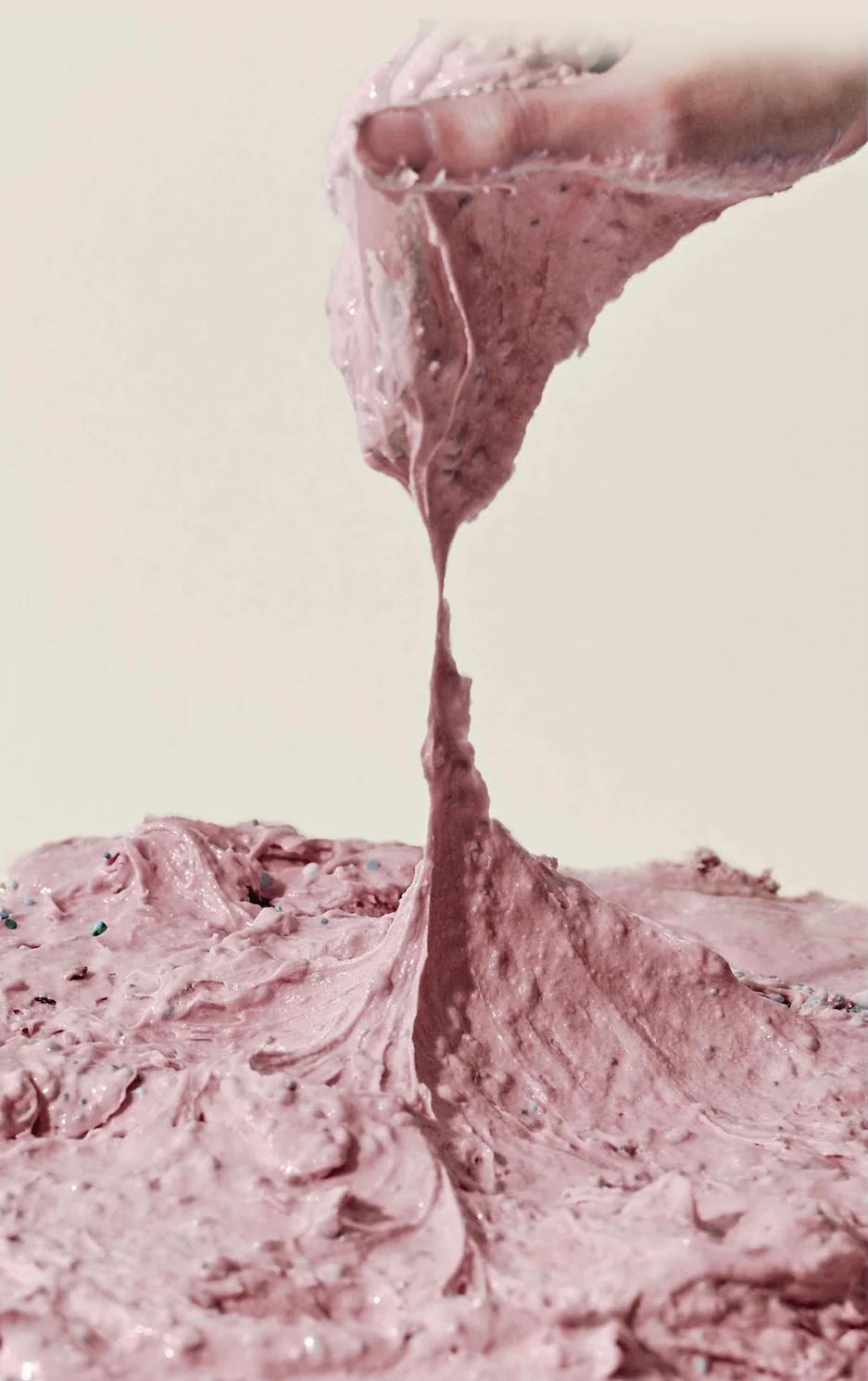 Texture de pâte rose à particules étirée avec les doigts