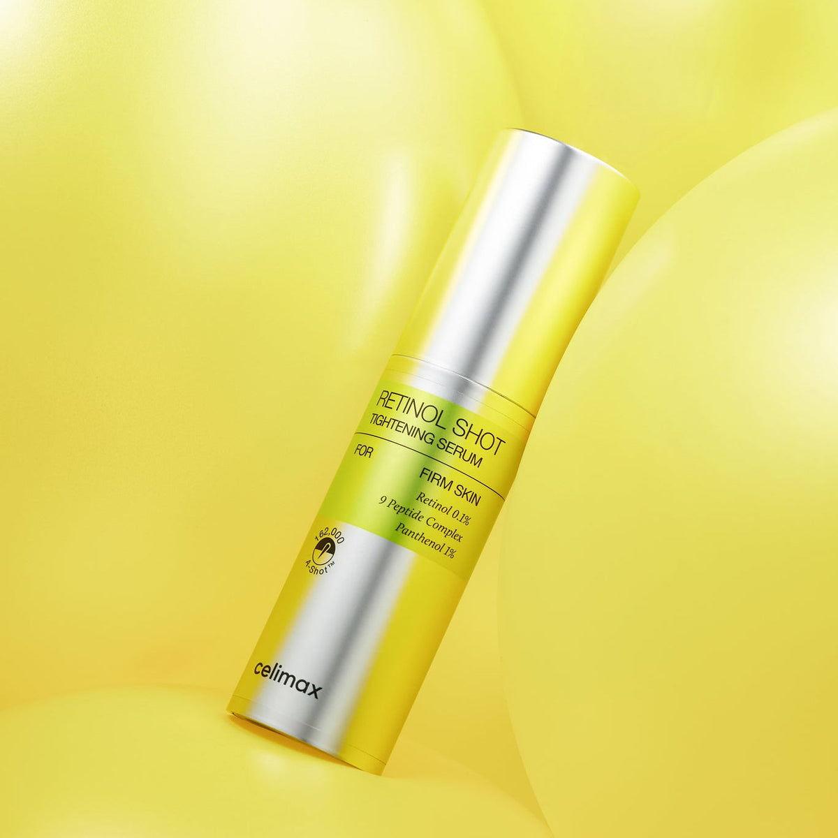 Flacon argenté de sérum présenté sur une surface jaune