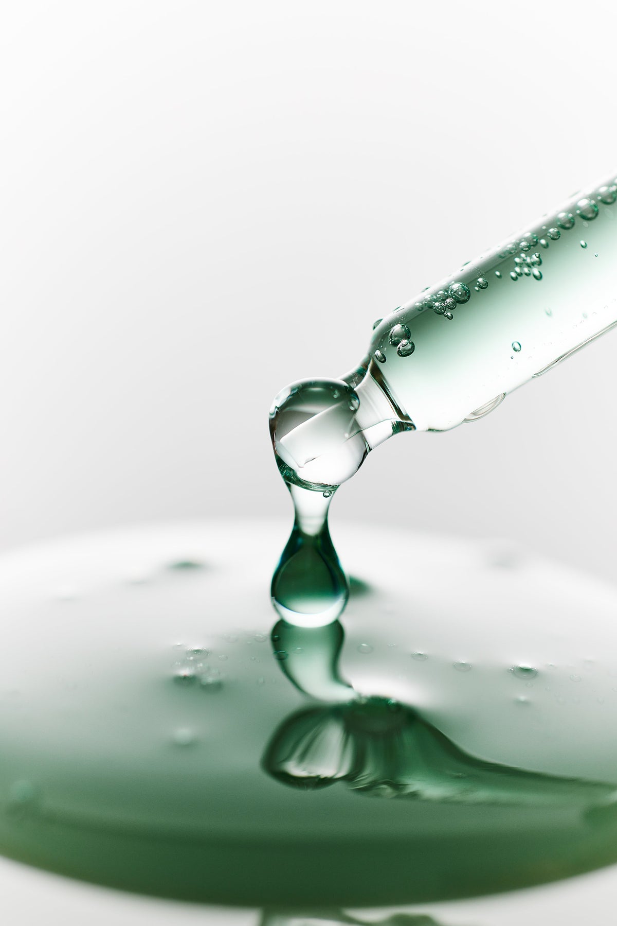 Goutte de sérum vert tombant d&