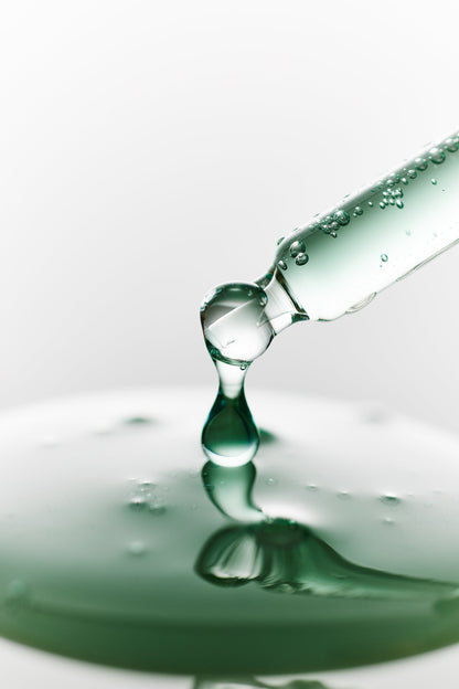 Goutte de sérum vert tombant d&