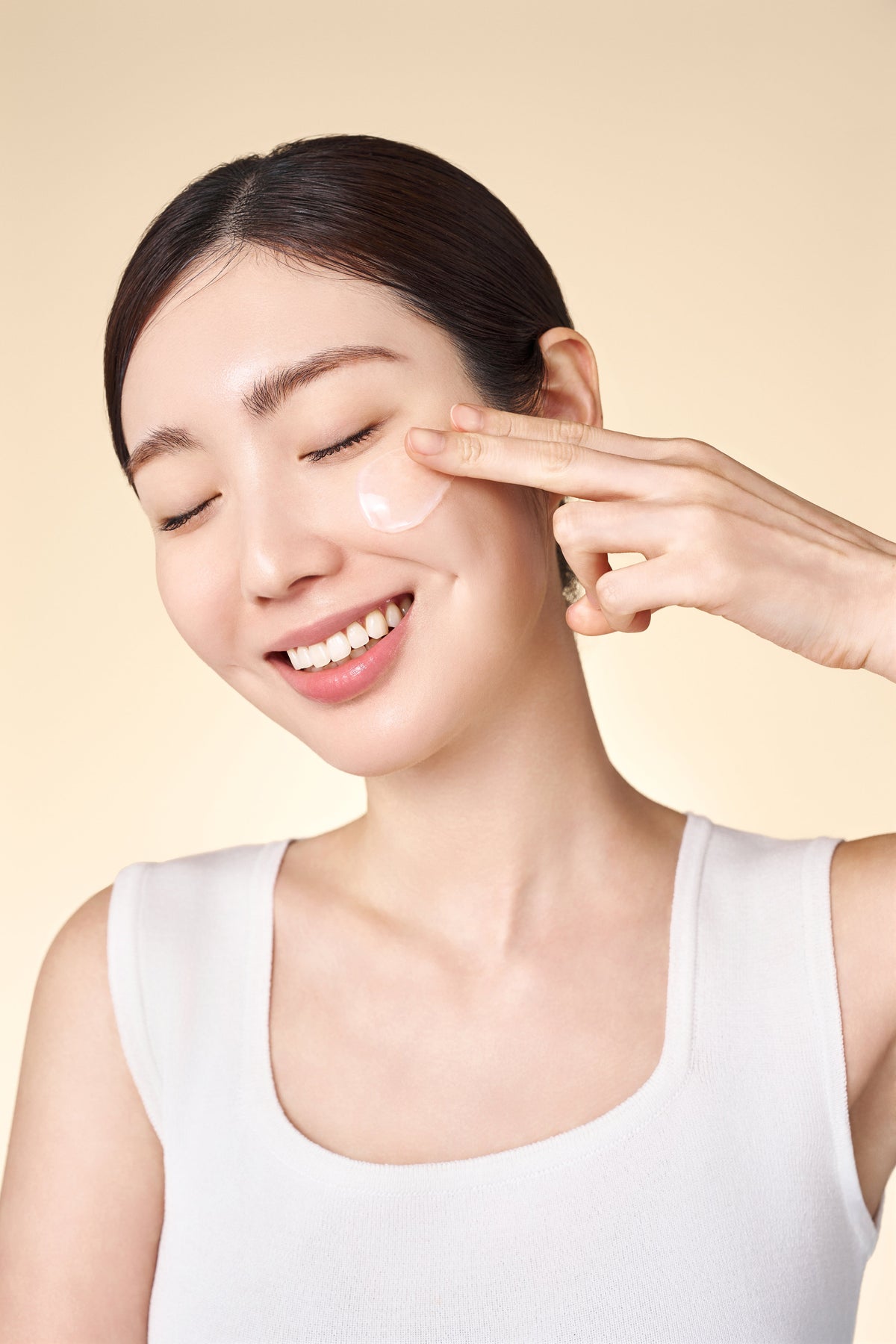 Gel-crème blanc appliqué sur la joue du bout des doigts